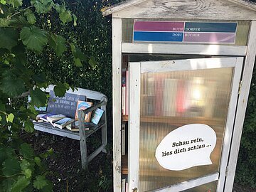 Öffenlicher Bücherschrank in der Bürgermeister-Rößner-Straße 1in Buchdorf Blick auf den öffentlich zugänglichen Bücherschrank in der Bürgermeister-Rößner-Straße 1 in Buchdorf mit daneben stehender Sitzgelegenheit.