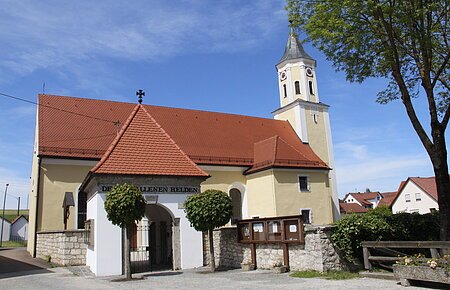 Blick auf die Pfarrkirche St. Richard mit dem gemauerten Torbogen.