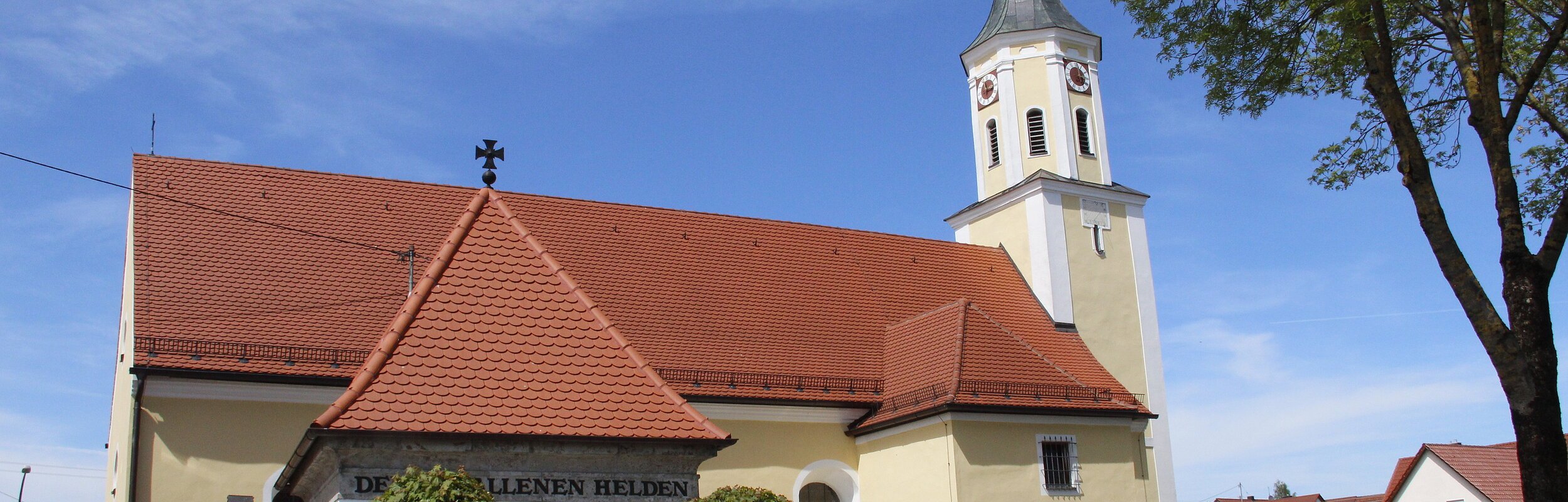 Blick auf die Pfarrkirche St. Richard mit dem gemauerten Torbogen.