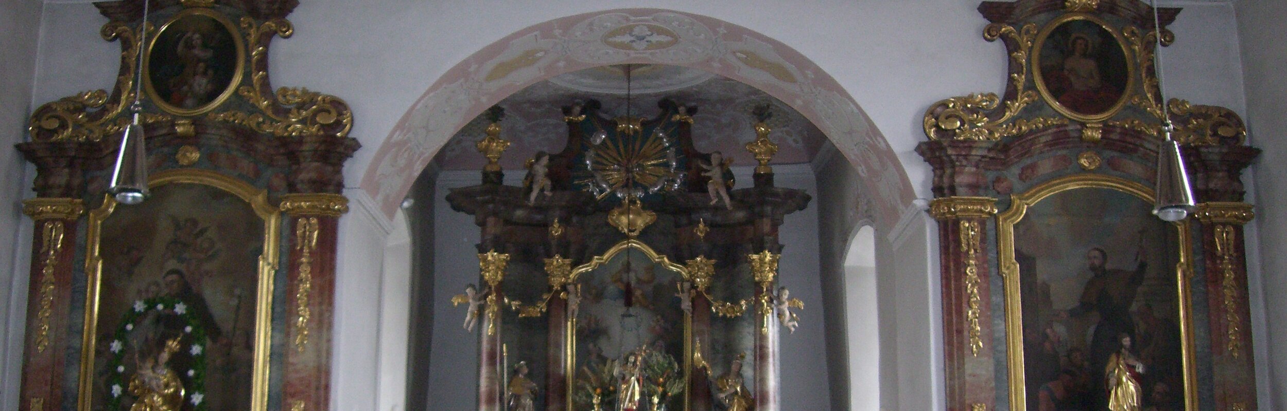 Blick auf den Altar und die beiden rechts und links liegenden Seitenaltäre