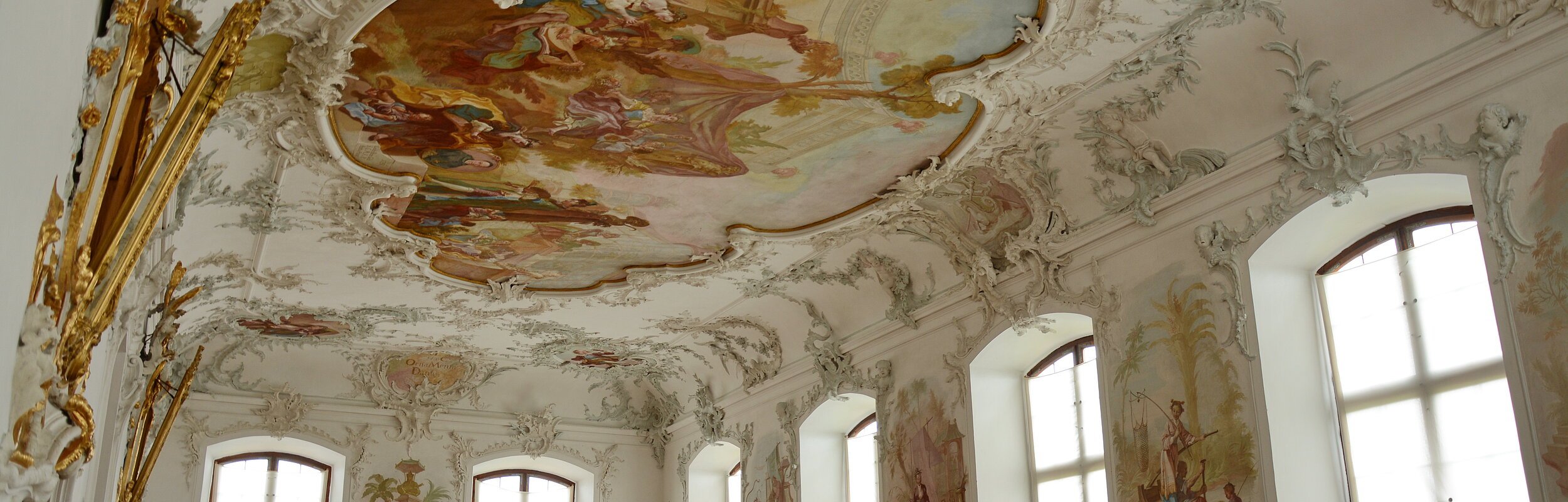 Blick auf den hellen Festsaal mit seinen Deckengemälden im Schloss Leitheim