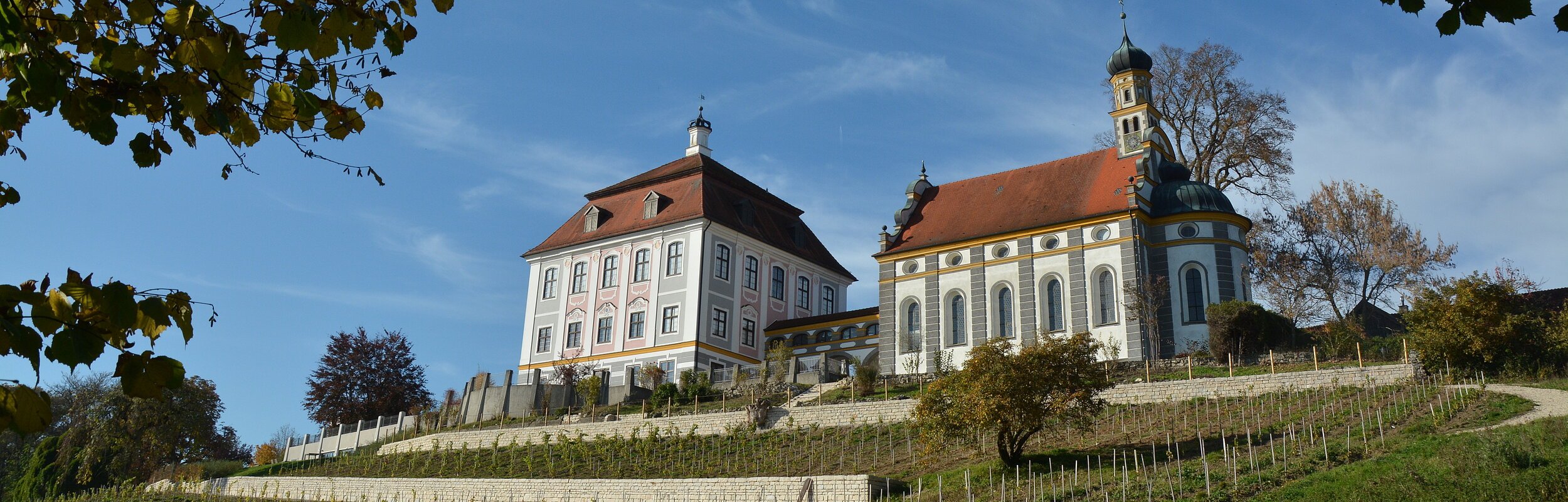 Außenansicht auf Schloss Leitheim mit davor liegendem Weinberg.