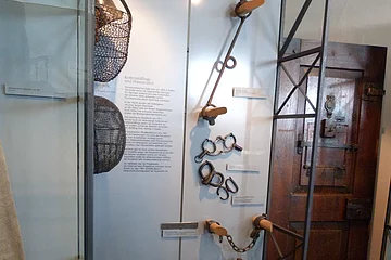 Ausgestelltes Folterwerkzeug in einer Vitrine
