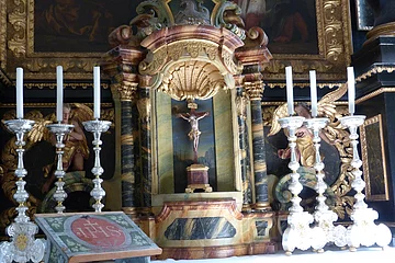 Altardetail - ein Kreuz umrahmt von Kerzen