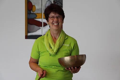 Frau Margarete Günter mit einer Klangschale in der Hand.