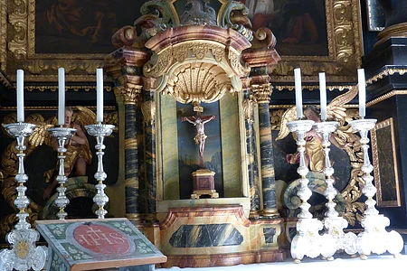 Altardetail - ein Kreuz umrahmt von Kerzen