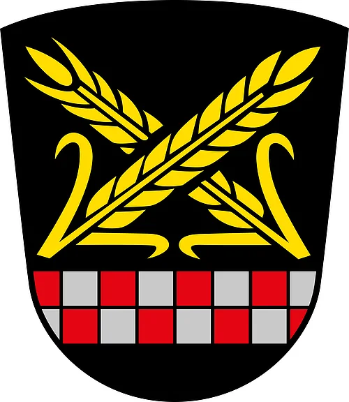 Das Wappen des Monheimer Stadtteils Itzing. Wappen mit zwei gekreuzten goldenen Ähren über einem rot-silbernen Schachbrettmuster auf schwarzem Hintergrund.