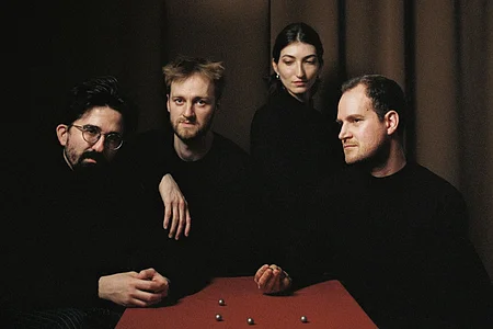 Sie sehen das Quatuor Agate in der aktuellen Besetzung an einem Tisch sitzen