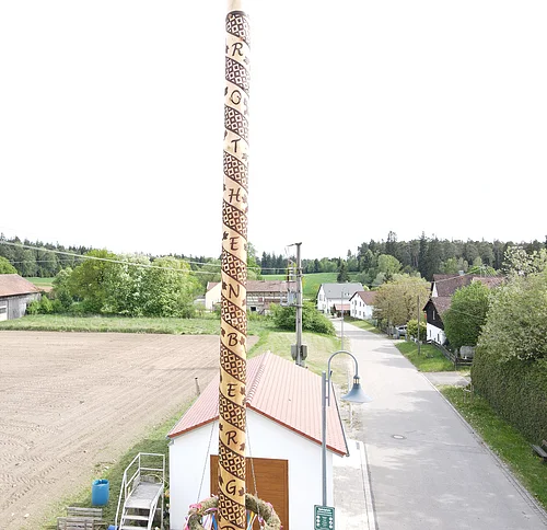 Maibaum 2026 Rothenberg Maibaum mit spiralförmiger Schrift in einem Dorf mit Häusern, Straße und Feldern im Hintergrund. Maibaum 2026 Rothenberg